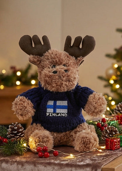 Plyschälg 15 cm med vit stickad Finland-tröja – nordisk souvenir och dekorativ figur. Mörkblå